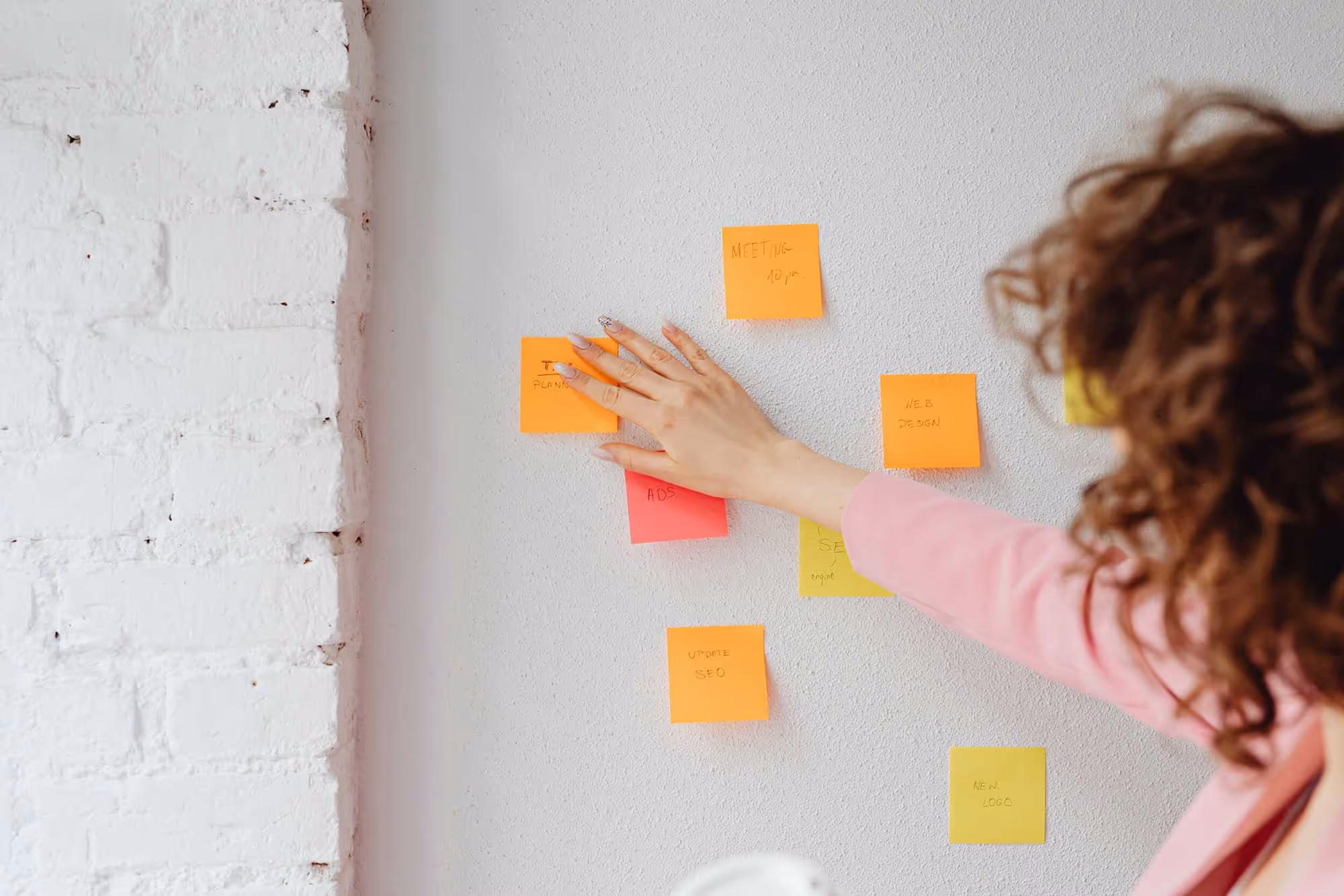 Buyer's journey playbook cover image - Woman organizing sticky notes on wall representing strategic planning and buyer journey mapping