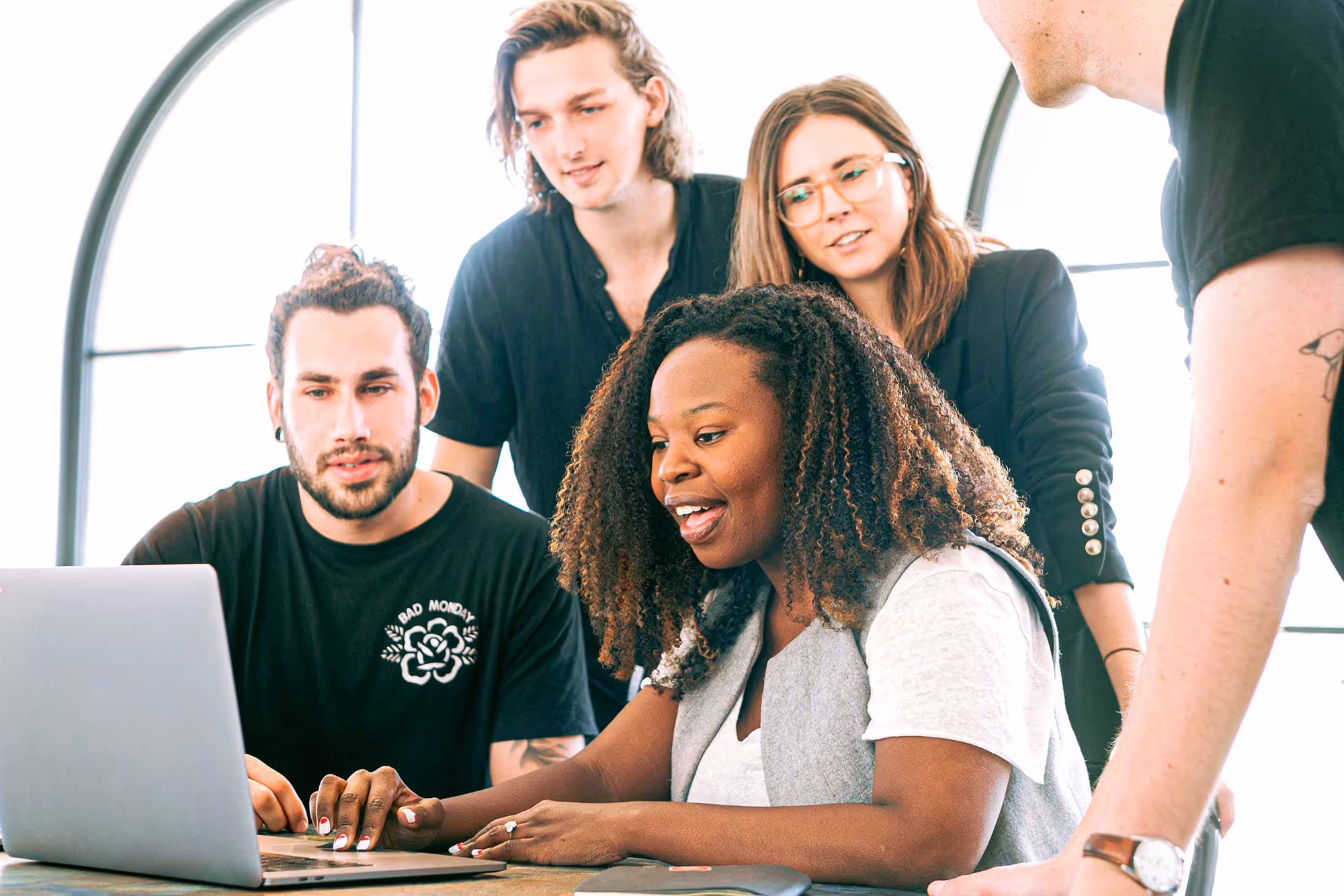 Marketing automation playbook cover image - Team members collaborating around laptop representing email marketing automation strategies
